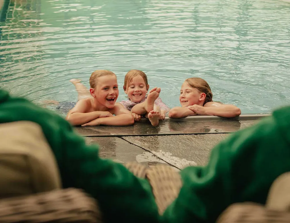 Tre glade barn ved bassengkanten i Pool Club