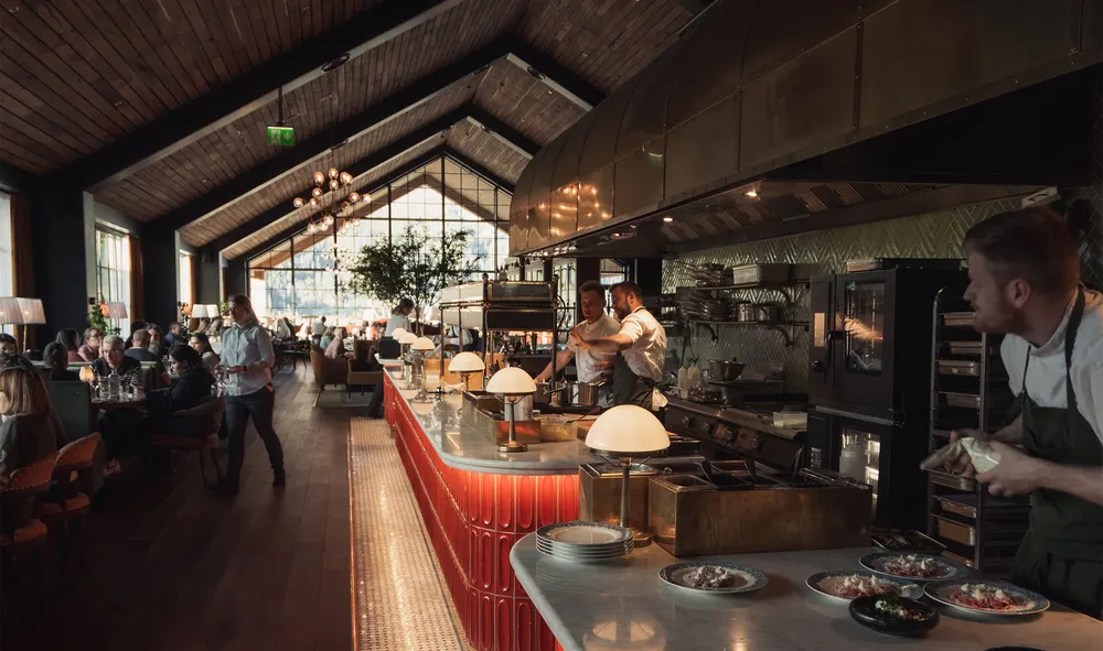 Restauranten med åpent kjøkken, marmordisk og stemningsfull spisesal