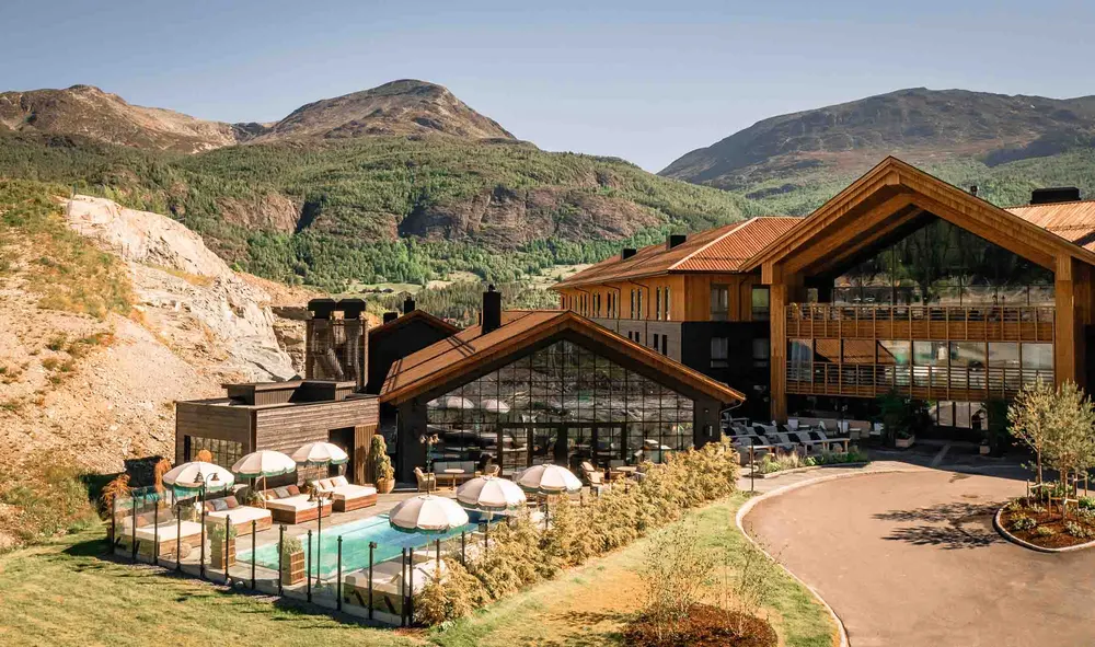 Fýri Resort om sommeren med utendørsbasseng og grønne fjell rundt